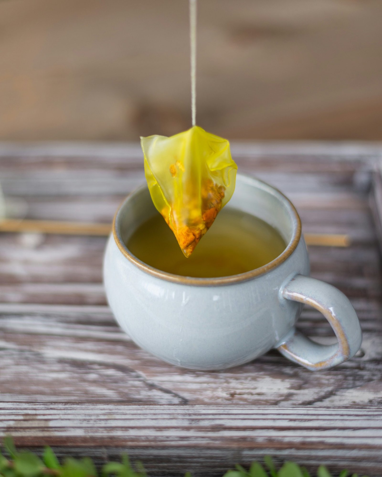 white ceramic teacup with yellow leaf on it