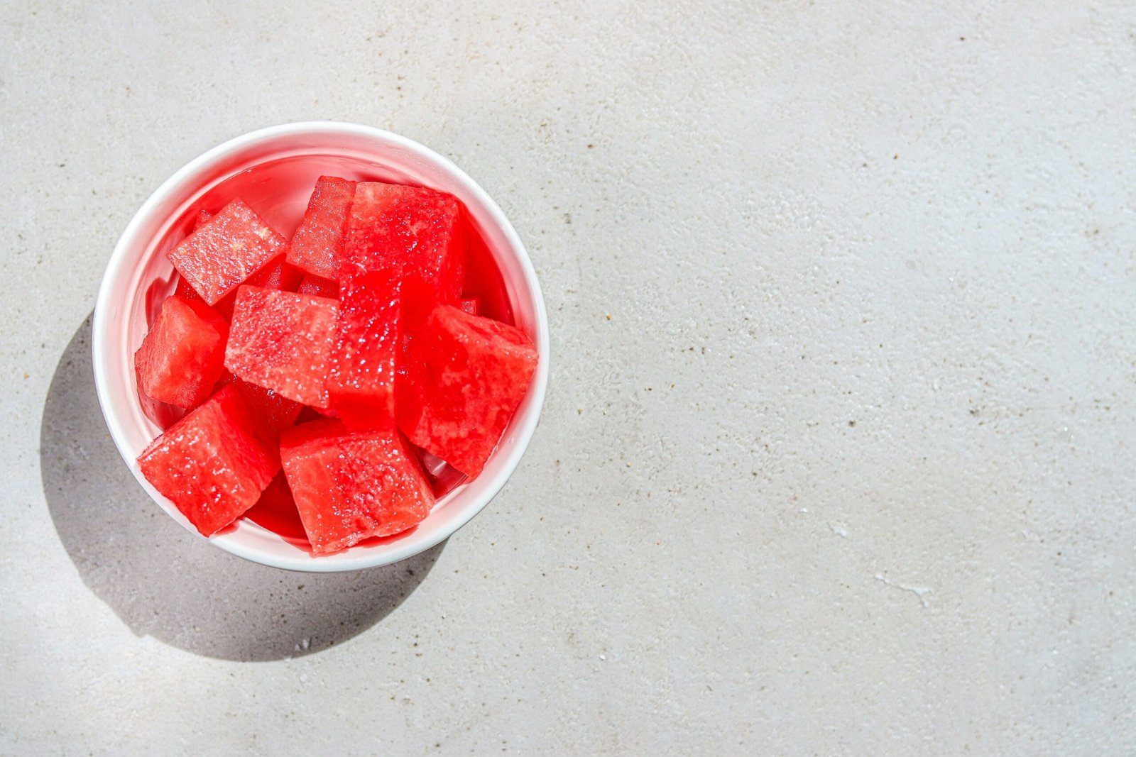 A bowl of watermelon cubes on a table